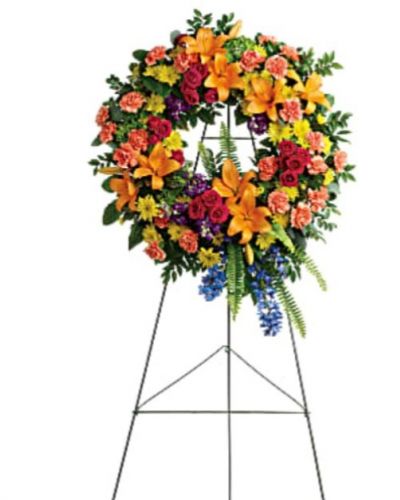 <div id="mark-1" class="m-pdp-tabs-marketing-description">Like a beacon of love and hope, this glorious wreath of hydrangea, roses and lilies echoes the joy of your precious memories.</div>
<div id="desc-1">
<ul>
<li>This wreath features green hydrangea, hot pink spray roses, orange asiatic lilies, orange carnations, blue delphinium, purple stock, yellow cushion spray chrysanthemums, huckleberry, variegated pittosporum, sword fern, silver dollar eucalyptus, and lemon leaf.</li>
<li>Delivered on a wire easel.</li>
</ul>
</div>