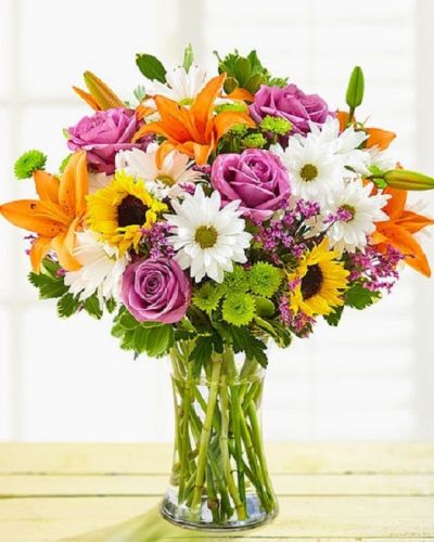 <p>Make their day twice as nice…for the same price! Our vibrant bouquet of roses, lilies, sunflowers, button poms and more is artfully arranged so that you can express yourself perfectly for any reason, or no reason at all!</p>
