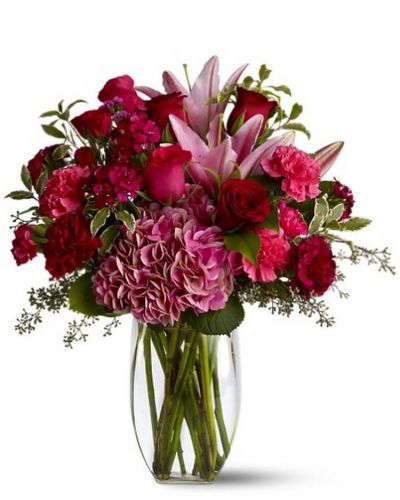Make a lovely lady blush with a generous mix of wine-hued blossoms such as roses, hydrangea, Asiatic lilies and more - in rich shades of burgundy, red and pink - delivered in a simple glass vase. With over half a dozen different varieties of flowers, it's a colorful and rare gift for any occasion. A mix of red, pink and burgundy flowers such as roses, Asiatic lilies, hydrangea, carnations and Sweet William – accented with greenery – is arranged in a clear glass vase.